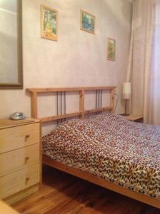 ニジニ・ノヴゴロドにあるApartment on Proviantskayaのベッドルーム(木製ベッド1台、ドレッサー付)