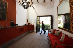 a person walking into a restaurant with a red couch at San Agustin Monasterio de la Recoleta in Urubamba