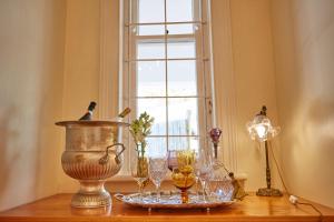 a table with glasses on it with a window at Villa Puccini in Cape Town