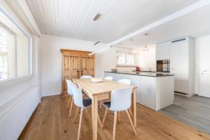 a kitchen and dining room with a wooden table and chairs at LAAX Homes - Casa Majo 5,5 in Flims