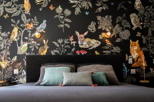 a bedroom with a bed with a wall covered in wallpaper at Le 49 Côté Parc & SPA in Domblans