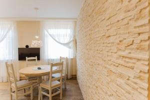 una sala da pranzo con tavolo e parete in pietra di Brand-New Deluxe Apartment in Liepāja a Liepāja