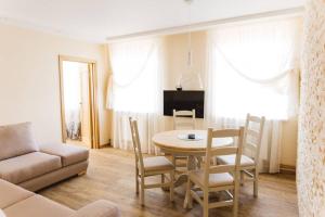 een woonkamer met een tafel en stoelen en een bank bij Brand-New Deluxe Apartment in Liepāja in Liepāja