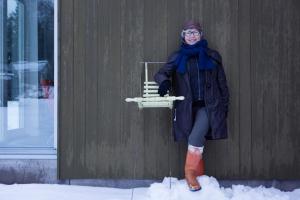 a woman leaning against a wall in the snow at Arthotel Tornedalen in Risudden