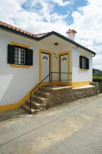 a white house with two doors and a staircase at Casas DeCá & DeLá in Ponte de Lima