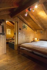 a bedroom with a bed in a room with wooden walls at CORTE DI CAVNE' in Miazzina