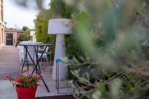 un patio con una mesa, una lámpara y algunas plantas en Soleil et Jardin, en Sanary-sur-Mer