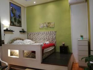 1 dormitorio con 1 cama en una habitación con paredes verdes en Smart City Apartment 2, en Budapest