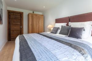 - une chambre avec un grand lit et une tête de lit en bois dans l'établissement Apartment Brevent Fodera, à Chamonix-Mont-Blanc