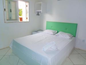 Un dormitorio con una gran cama blanca con cabecero verde. en RAFAELLO HOTEL, en São Borja