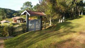 une clôture avec un portail bleu dans une cour dans l'établissement Um lugar para curtir, descansar e amar!, à Campos do Jordão