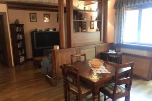 a dining room with a table and a television at Borgo Delle Ginestre in Pescasseroli