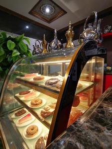 a display case filled with different types of pastries at فندق غالية احد in Al Madinah