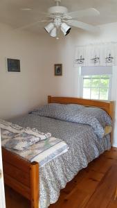 a bed in a bedroom with a ceiling fan at TeelCoveCottageMaine in Saint George
