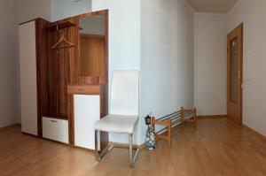 Una silla blanca en una habitación con suelo de madera en Ferienwohnung Hochwaldblick 2, en Morbach