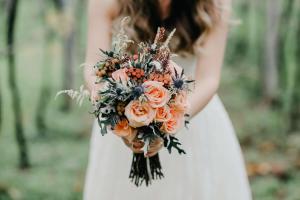 a bride holding a bouquet of orange flowers at Kimpton - Hotel Arras, an IHG Hotel in Asheville