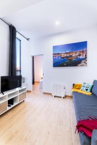 sala de estar con cama y TV de pantalla plana en Porto Belo Bolhao Apartments - Free Parking, en Oporto