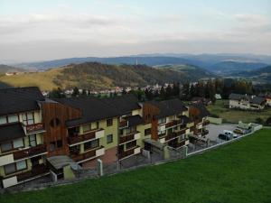 eine Reihe von Apartmenthäusern mit Bergen im Hintergrund in der Unterkunft Mountain Village Apartment Pinewood *** in Vyšné Ružbachy