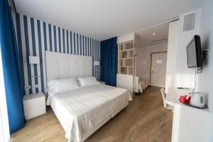 A bed or beds in a room at Hotel Fedora Riccione