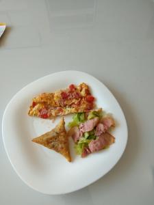 a white plate with two slices of pizza on it at Great house BnB near jkia in Nairobi