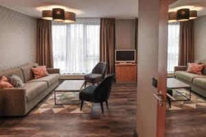 - un salon avec un canapé et une télévision dans l'établissement Eurostar Hotel, à Castrop-Rauxel