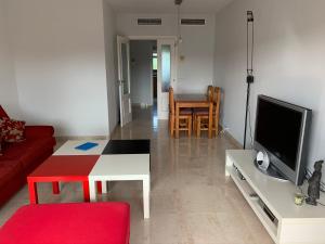 a living room with a red couch and a tv at Aquamaris-Denia Apartamento espectacular in Denia