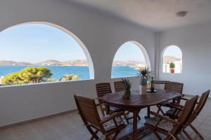a dining room with arched windows and a table and chairs at Port View House in Parasporos