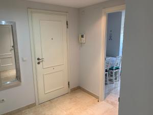 a white door in a room with a table at Aquamaris-Denia Apartamento espectacular in Denia