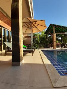a patio with an umbrella next to a pool at Alfa Beach (Adults only) in Cacha Pregos