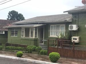 uma casa verde com uma cerca em frente em Residenciais Vista do Centro Gramado em Gramado