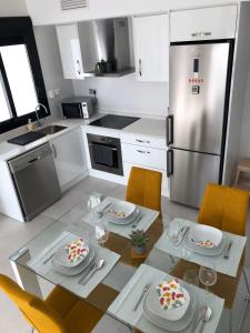 a kitchen with a table and a stainless steel refrigerator at Casa Ribalta in San Pedro del Pinatar