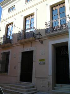 a building with two balconies and a door and stairs at Hostal Casa Museo La Pájara in Hellín