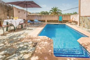 a swimming pool with a table and an umbrella at El Manantial in Montecorto