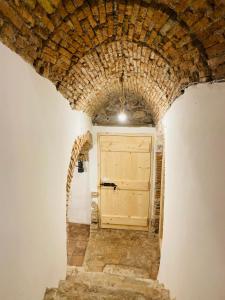 a tunnel with a wooden door in a brick wall at Ca' del Borgo in Venosa