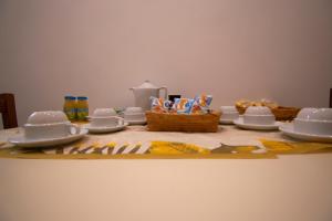 a table with plates and cups and snacks on it at Casual Stay Cairoli in Reggio di Calabria