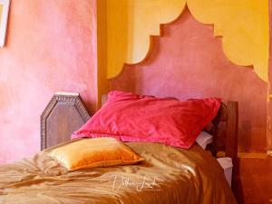 Una cama con dos almohadas encima. en Riad Tabhirte en Agdz