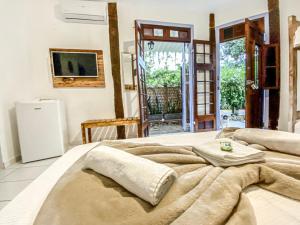 a bedroom with two beds and a tv on the wall at Vila Pequeá Ilhabela in Ilhabela