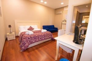 a bedroom with a bed and a blue chair at Casual Stay Cairoli in Reggio di Calabria