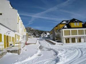 uma rua coberta de neve numa cidade com edifícios em Serra da Estrela Guest House na Covilhã