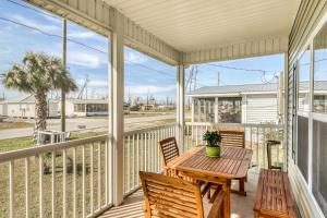 a screened porch with a wooden table and chairs at Mermaid Manor in Mexico Beach