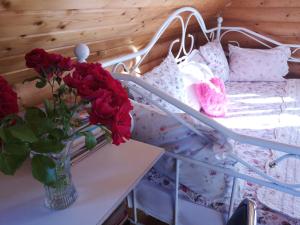 a vase of roses on a table next to a bunk bed at DvīņuMājas in Balvi
