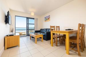 a living room with a couch and a dining room table at West Beach - Holiday Apartments in Westward Ho