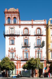 a tall building with balconies on a city street at Torreón Santa Cruz in Seville