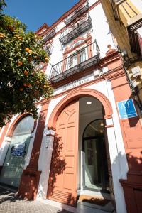 un accès à un bâtiment avec une arche dans l'établissement Torreón Santa Cruz, à Séville