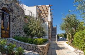 a house with a stone wall and stairs at Penthouse Donna Carmela in Anacapri