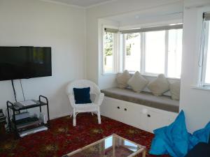 a living room with a couch and a window seat at Ridge Cottage - Oneroa Holiday Home in Oneroa