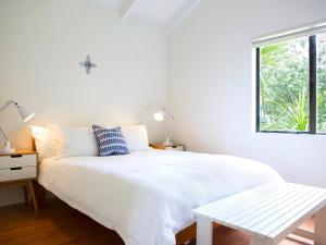 a white bedroom with a white bed and a window at Two Rooms Onetangi - Onetangi Holiday Home in Onetangi