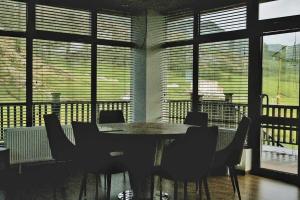 ein Esszimmer mit einem Tisch, Stühlen und Fenstern in der Unterkunft Takhi Resort in Yoliin Hural