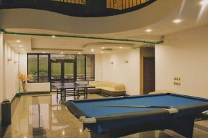a pool table in a room with two tables at Takhi Resort in Yoliin Hural