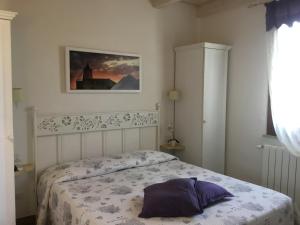 a bedroom with a bed with a purple pillow on it at Borgo della Luna in Birgi Vecchi